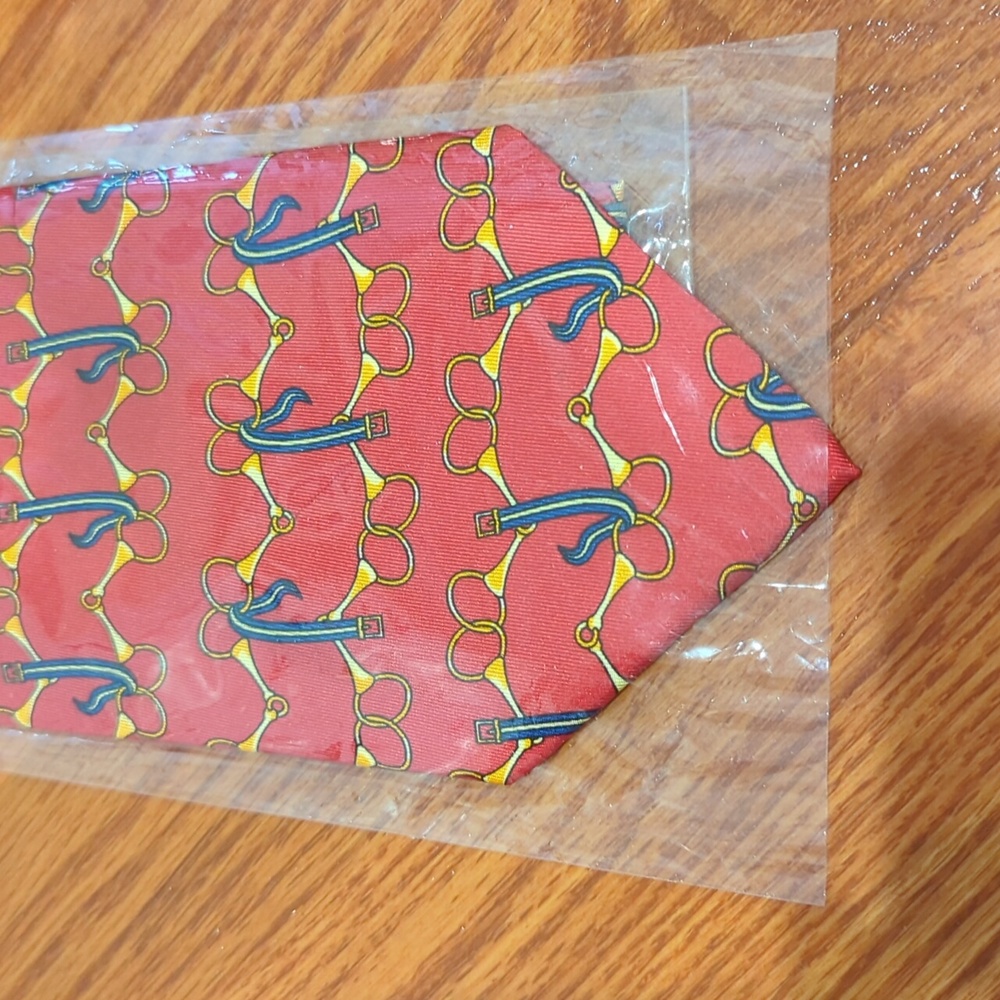 Red and gold horse bit 100% silk tie in packaging. 3.75"